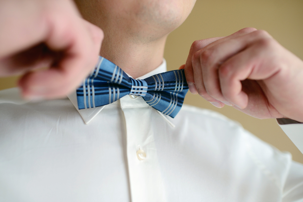 Man tying a blue bowtie